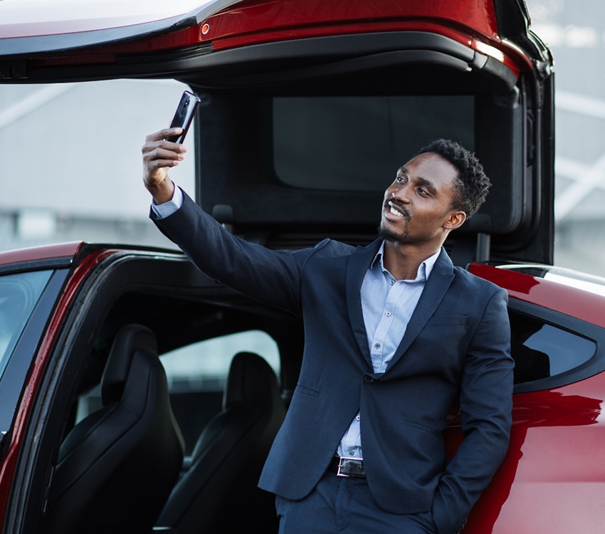 An influencer taking photo outside of car