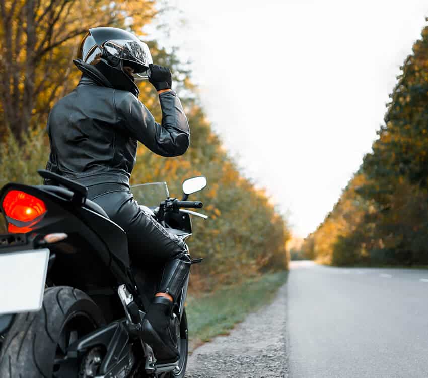 Woman pulled over at side of road on motorbike